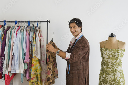 Tailor working in a clothing store and smiling