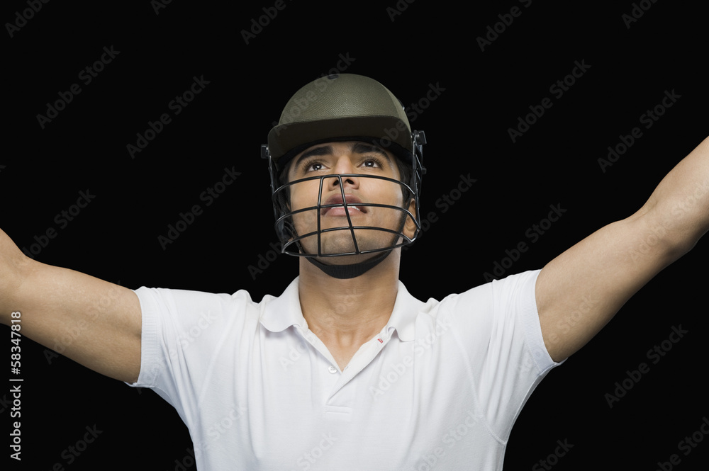 Cricket batsman celebrating with his arms raised