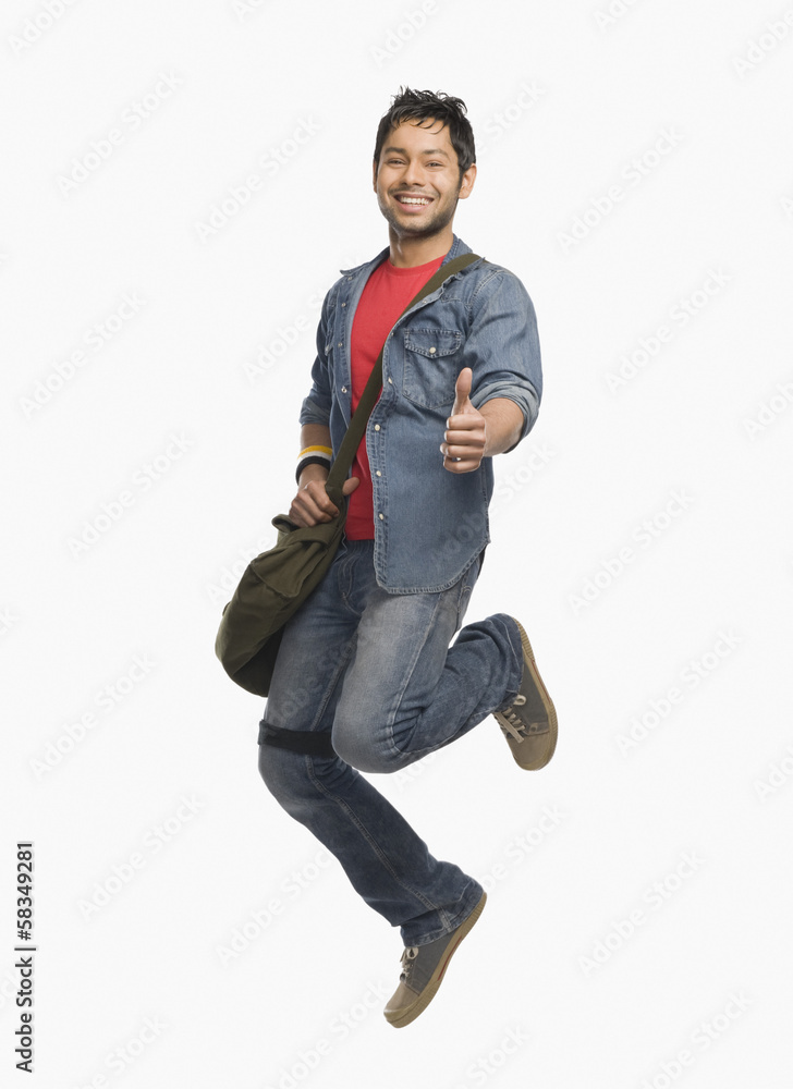 University student showing thumbs up and jumping