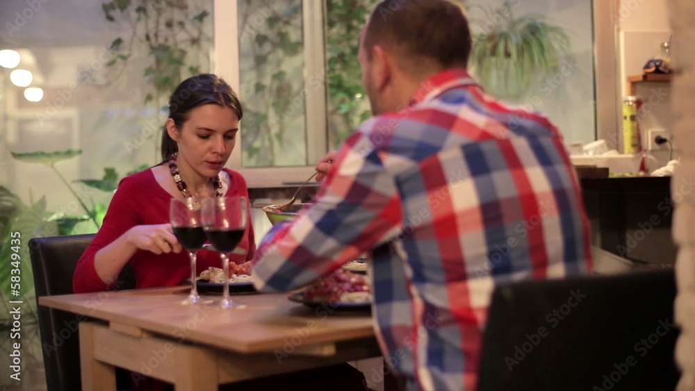 Young couple putting basil to the spaghetti at dinner time Young couple putting basil to the spaghetti at dinner time