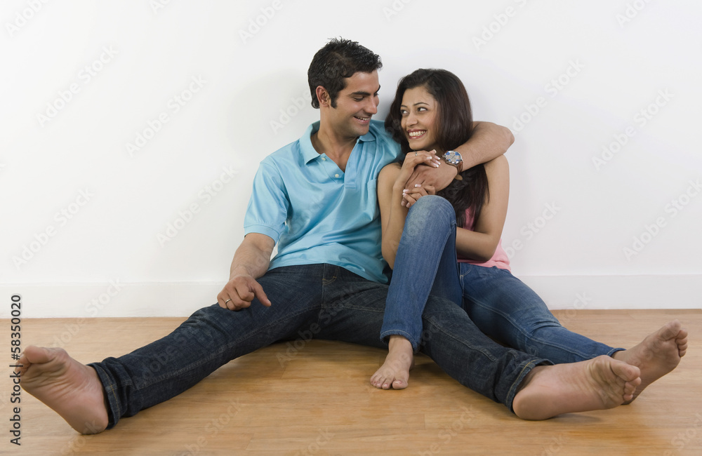 Couple sitting on the floor and smiling Couple sitting on the floor and smiling
