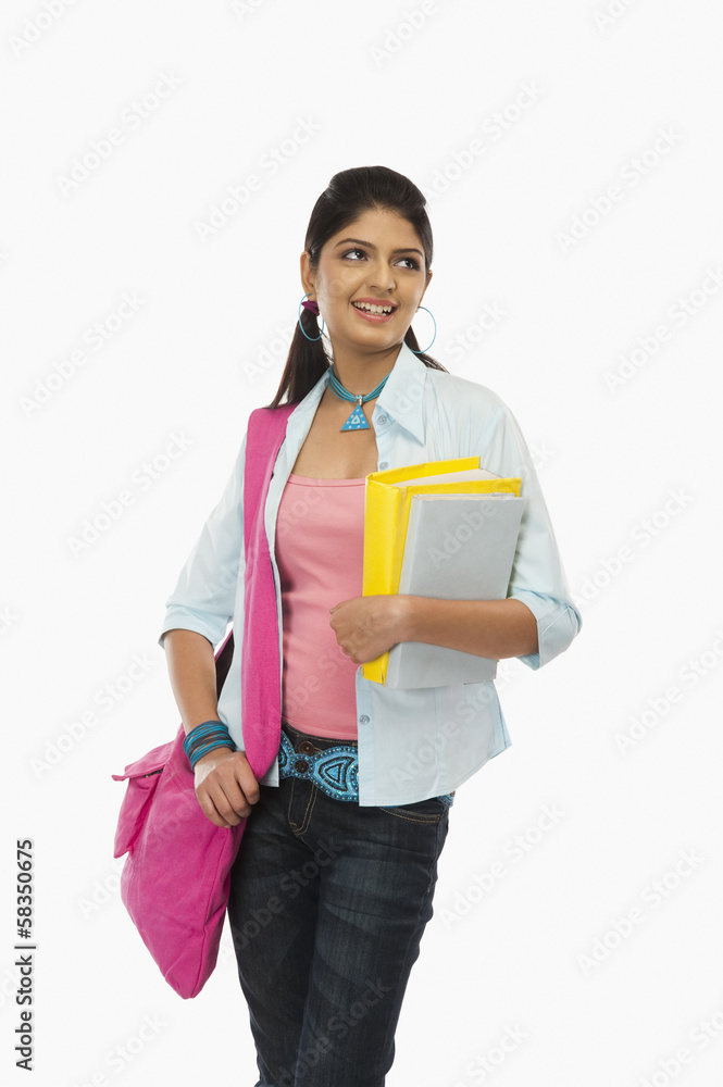 Female university student holding books and day dreaming Female university student holding books and day dreaming