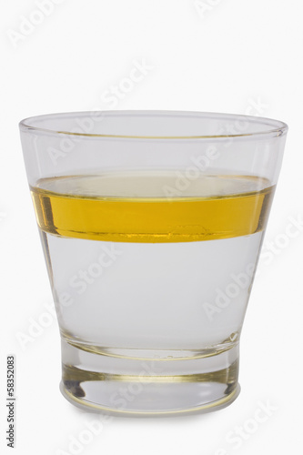 Oil floating on water surface in a glass