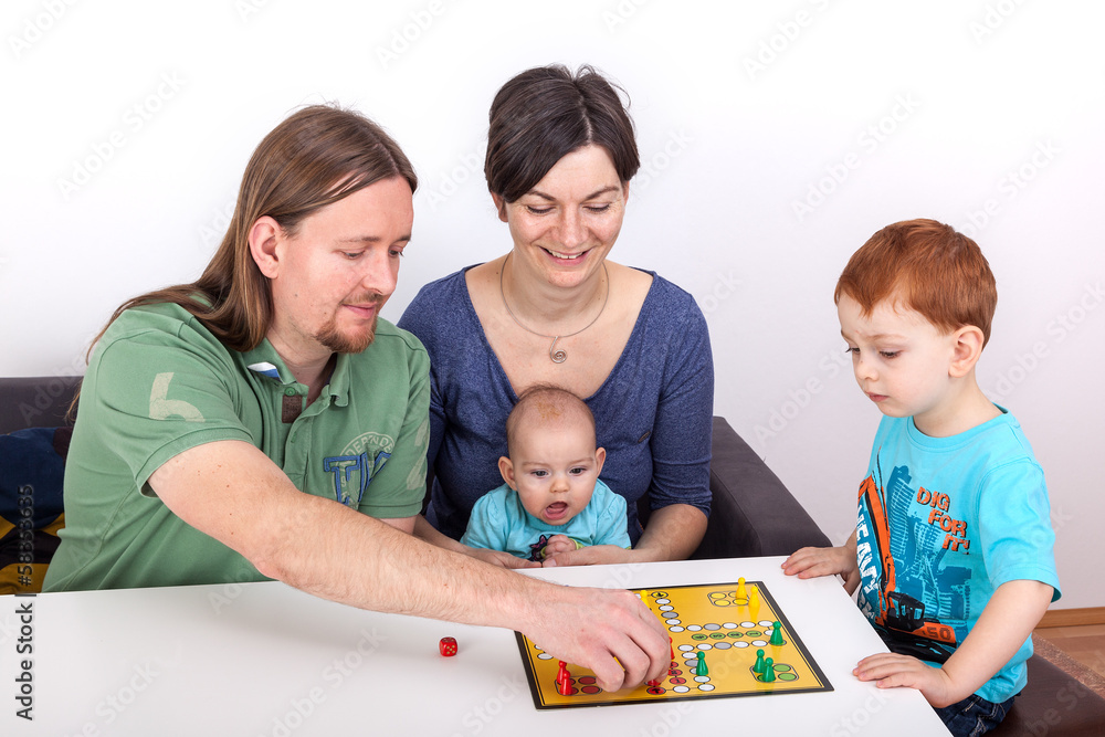 Parents with child and baby in the joint board game