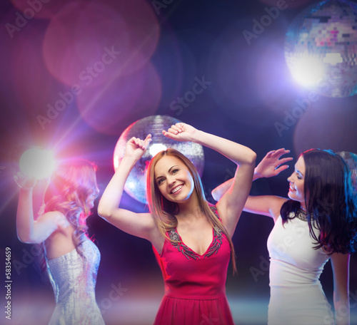 three smiling women dancing in the club