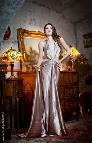 Young beautiful luxurious woman in long elegant dress. Beautiful