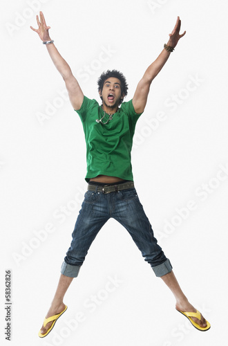 University student jumping with arms raised