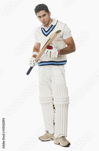 Cricket batsman holding a ball and bat