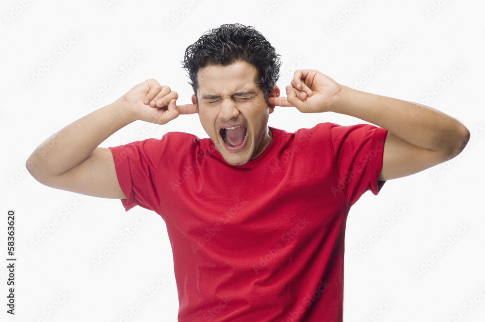 Man screaming with his fingers in ears Man screaming with his fingers in ears