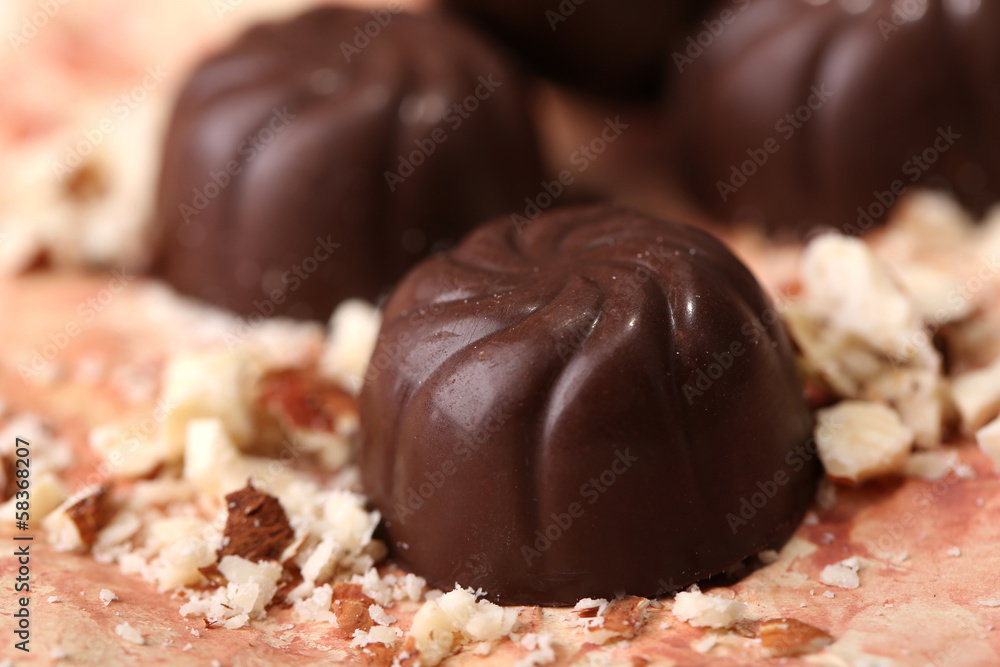 Chocolate candies with nuts, on color background Chocolate candies with nuts, on color background
