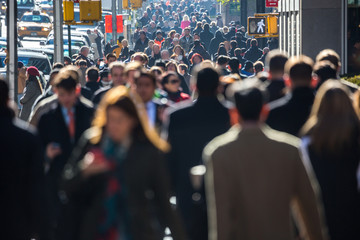 Anonymous crowd of people walking on city street