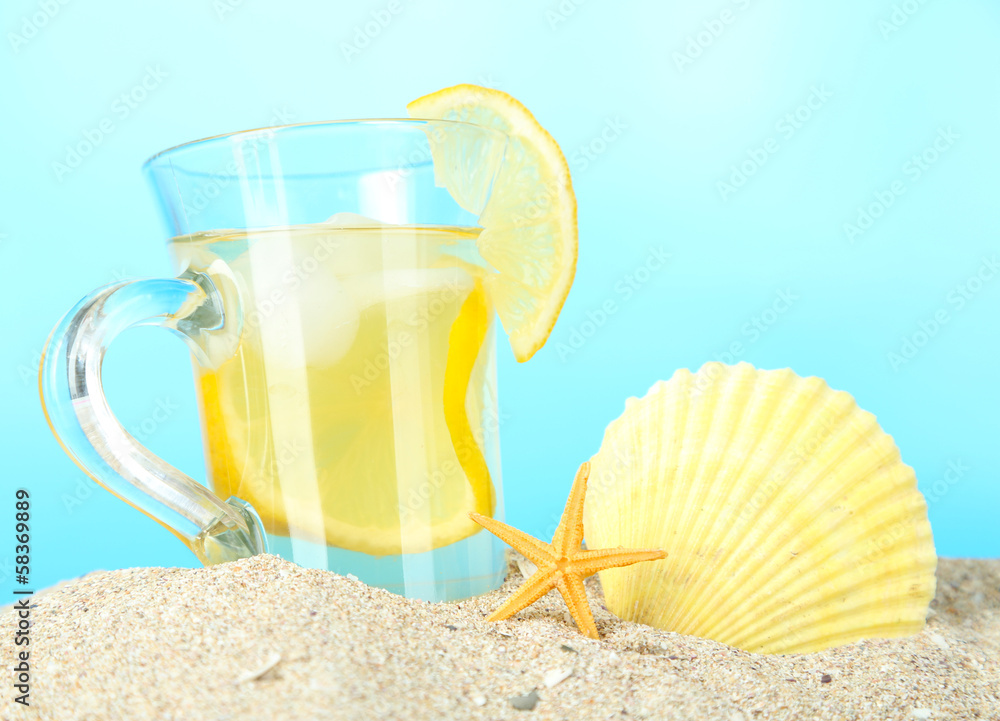 Cold tea in sand on blue background Cold tea in sand on blue background