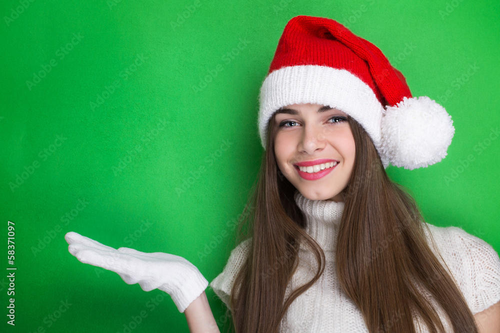 Happy teenage girl showing something on green background Happy teenage girl showing something on green background