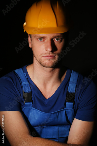 Portrait of young worker on dark background
