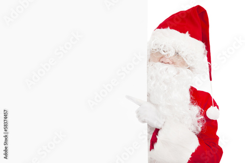 happy Santa Claus pointing at blank banner