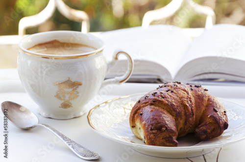 Coffee, croissant and book