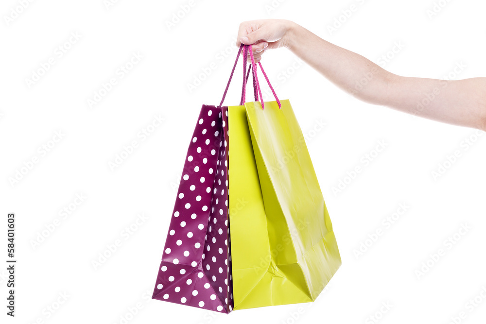 Female hand holding colorful shopping bags, isolated on a white