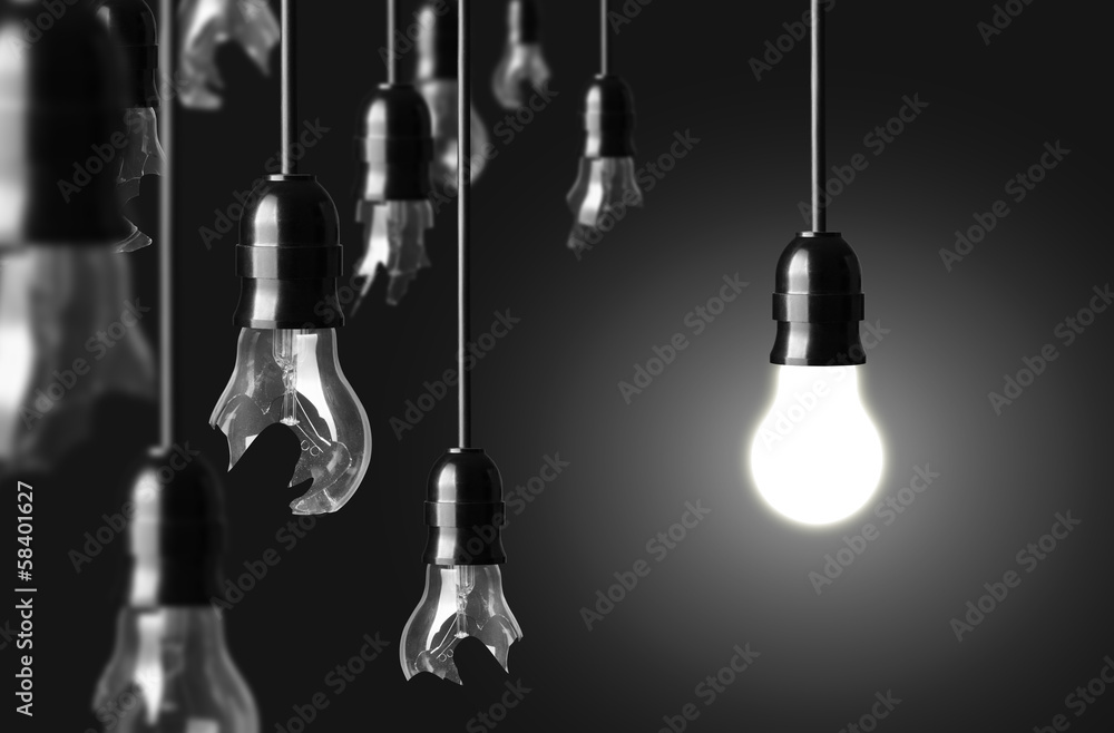 idea concept with broken bulbs and one glowing bulb - obrazy, fototapety, plakaty 