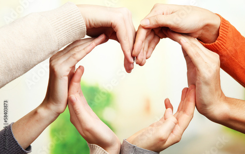 Human hands in heart shape on bright background
