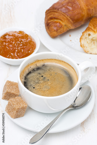 breakfast with black coffee, croissants and orange jam