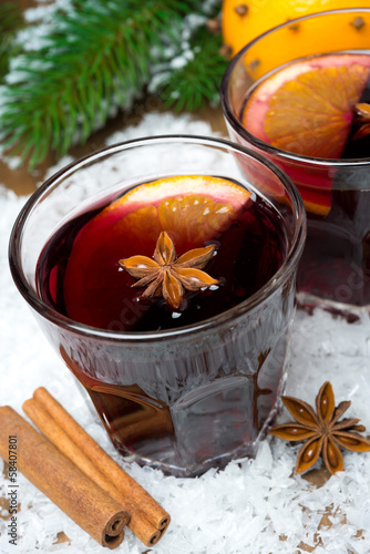 spicy mulled wine in glasses on the snow, close-up