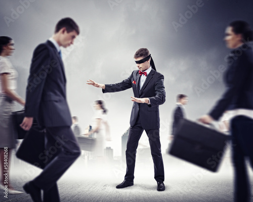 Businessman in blindfold among group of people