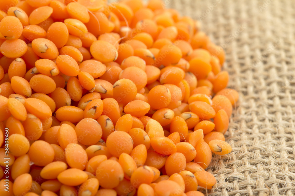 close up of red lentils on jute background close up of red lentils on jute background
