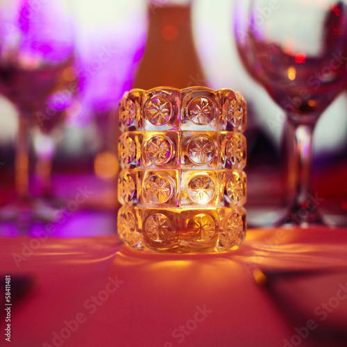 Candle on restaurant table over bokeh background