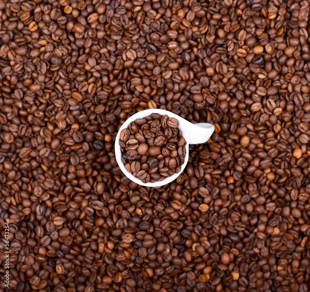 Cup of coffee filled with coffee beans abstract view