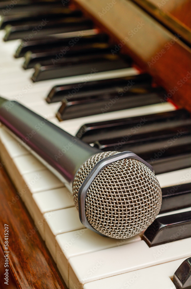 Obraz premium Microphone on keyboard of piano