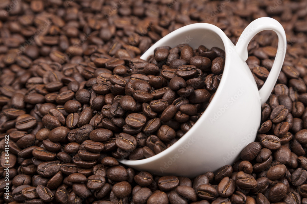 White cup with coffee beans close up White cup with coffee beans close up