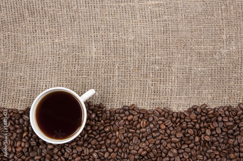 White cup with coffee on burlap
