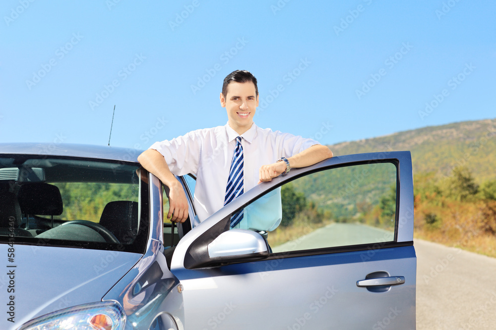 Smiling young male with tie posing next to his car Smiling young male with tie posing next to his car