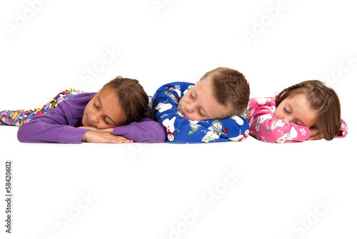 Three kids laying down asleep in winter pajamas