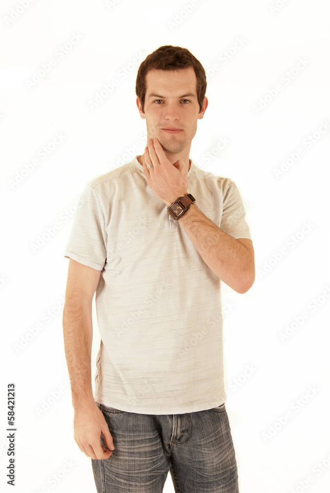 casual dressed young man standing scratching his chin casual dressed young man standing scratching his chin