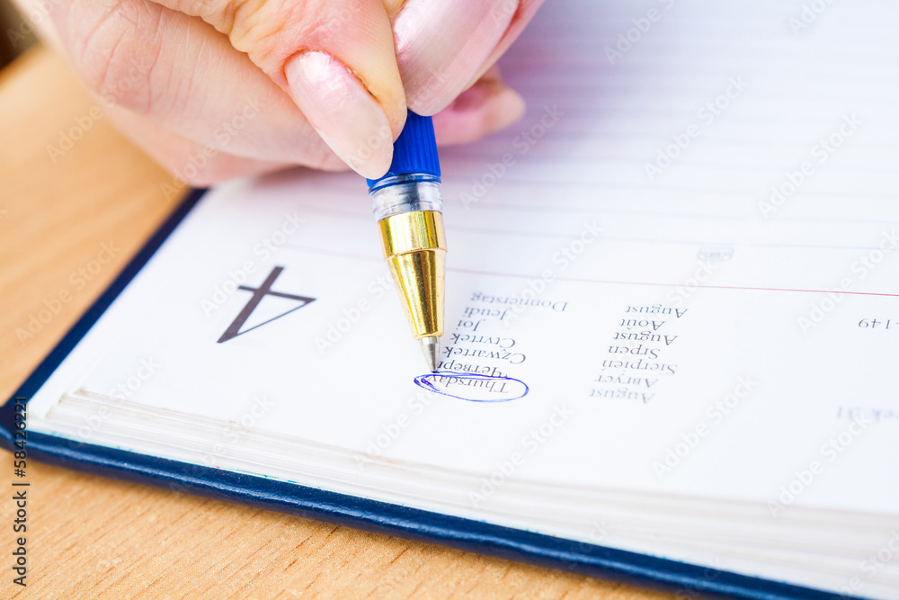 Business Woman Writing with pen in notepad Business Woman Writing with pen in notepad