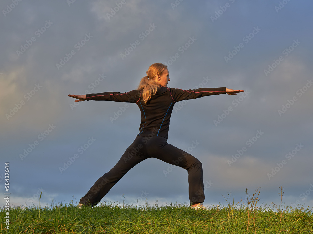 Pretty female doing yoga on top of the hill Pretty female doing yoga on top of the hill