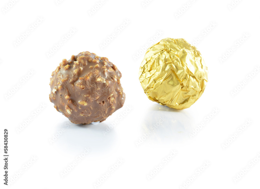 Sweet chocolate candy wrapped in golden foil isolated on white b