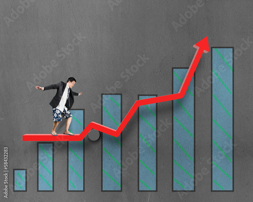 Businessnan surfing on growth red arrow with histogram drawing photo