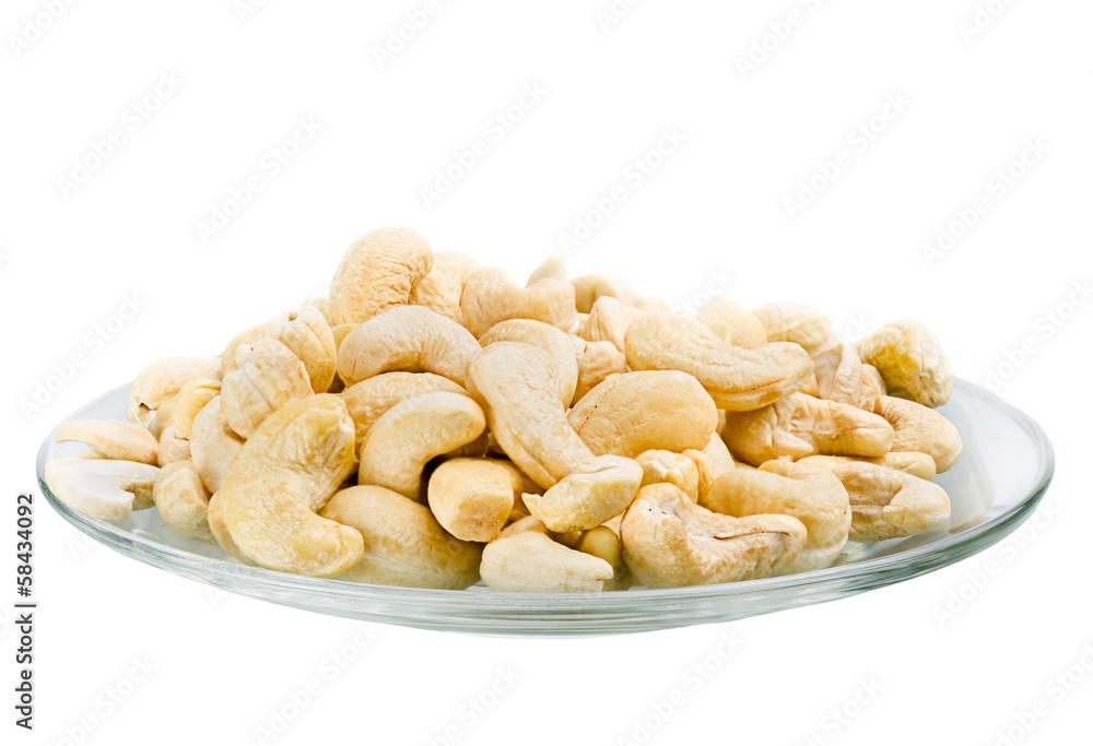 Fototapeta premium Saucer with a row cashew nuts isolated on white background