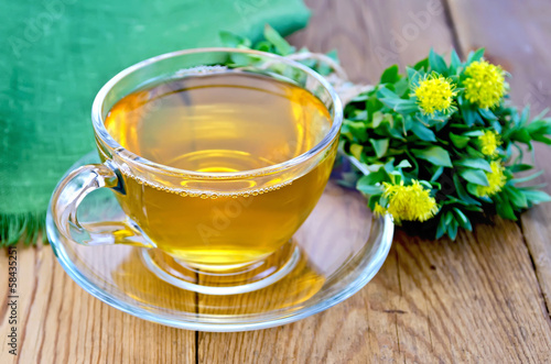 Herbal tea with a bouquet of Rhodiola rosea on the board