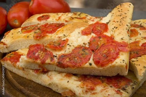 Focaccia with tomatoes and oregano close up