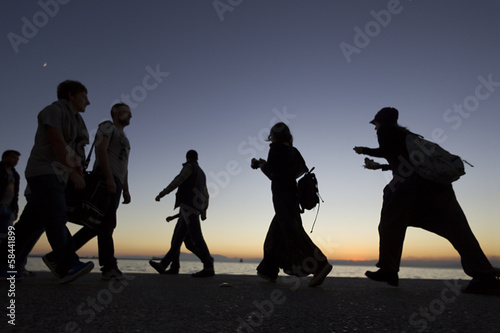Silouetes of people walking on the sunset photo