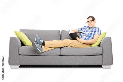 Young male on a sofa reading a book © Ljupco Smokovski
