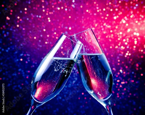 champagne flutes with bubbles on blue tint light bokeh