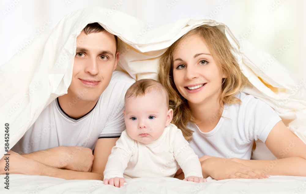 happy family in bed under a blanket happy family in bed under a blanket