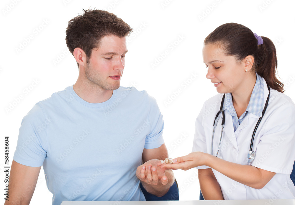 Patient Looking At Doctor Holding Hearing Aid Patient Looking At Doctor Holding Hearing Aid