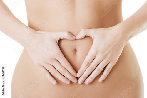 Attractive woman making heart shape with her hands on her belly