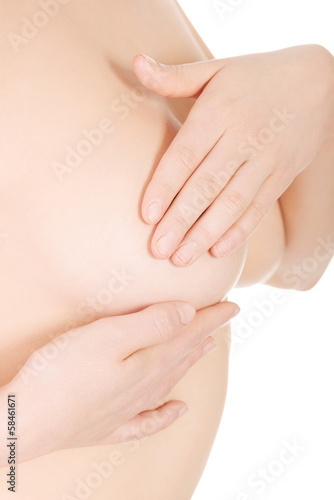 Young woman examining her breast for signs of breast cancer