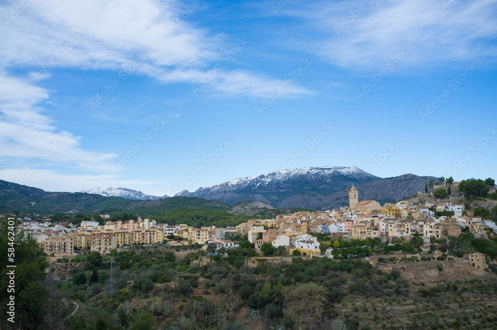 Mediterranean village surrounded by snow caped mountains